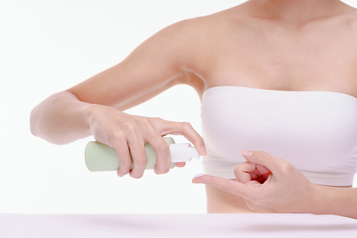 A female is pumping a moisturizer onto her finger. Skin care