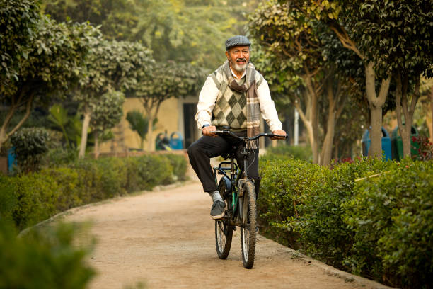 istock Happy old man riding bicycle on garden path 1455421635