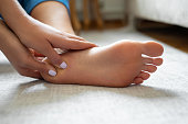 Young woman massaging her foot