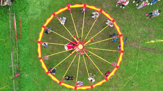 Carnival Merry Go Round aerial top view. Drone tracking rotation shoot.