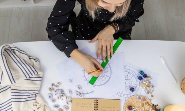 istock Woman astrologer draws a natal chart. Selective focus. 1455424991