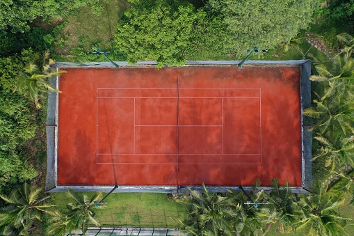 An aerial view of a tennis field surrounded by beautiful trees