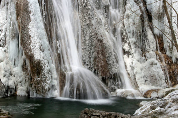 istock Chilling view of a waterfall flowing downstream in a winter forest 1455430671