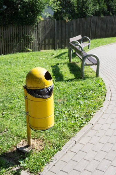 istock Vertical shot of a yellow trash bin in a park 1455431407