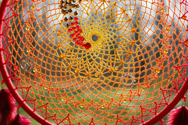 Abstract image of tangled spiders web with dew wrapped around thorns of gorse bush in early morning golden light