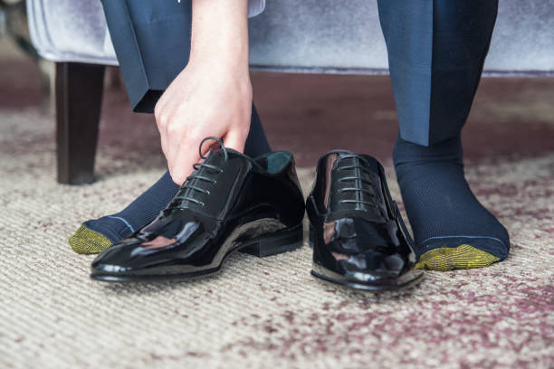 istock Groom putting on his shoes and getting dressed for the wedding ceremony 1455435345