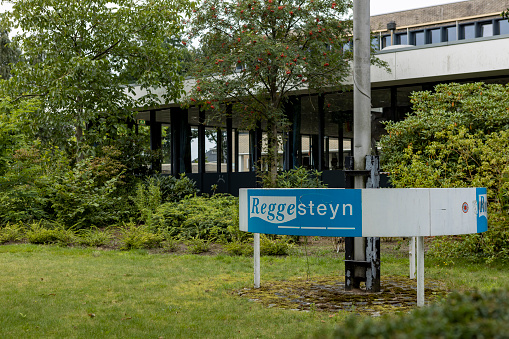 Nijverdal, Netherlands – August 13, 2021: Flag pole and name before entrance facade canopy of Reggesteyn secondary education exterior school building