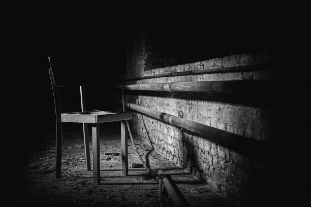 istock Grayscale of a single chair in an abandoned empty room. 1455438797