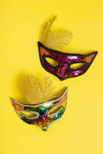 istock Festive face masks for carnival or masquerade celebration on colored background top view 1455441551