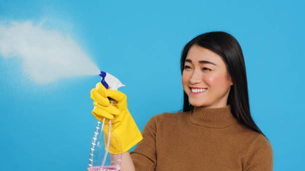 istock Housekeeper wearing yellow rubber gloves while holding spray and duster during houseclean 1455443171
