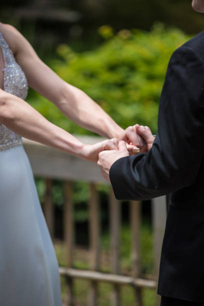 istock Vertical shot of a bride and groom holding hands 1455446413