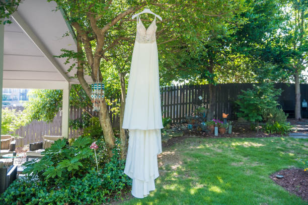 istock Bridal dress hanging from the tree outdoors - wedding concept 1455446440