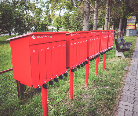 Sianozety, Poland – October 27, 2016: The row of red Poczta Polska locked mail boxes by the sidewalk in Sianozety, Poland