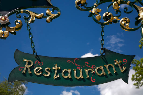 The iron shield showing the direction to the restaurant against a cloudy sky