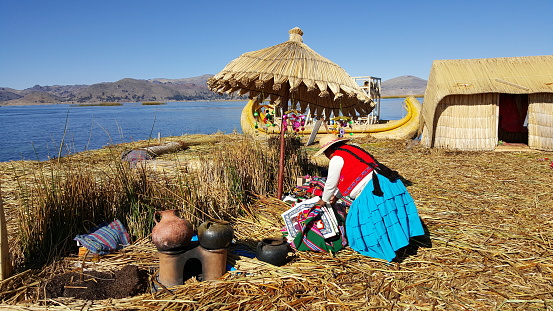 Titicaca, Peru – August 25, 2015: Native Peruvian woman on the floating islands of Lake Titicaca between Peru and Bolivia.