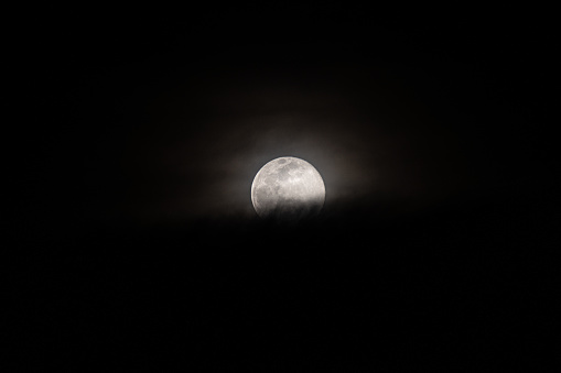 The full moon in the dark night sky