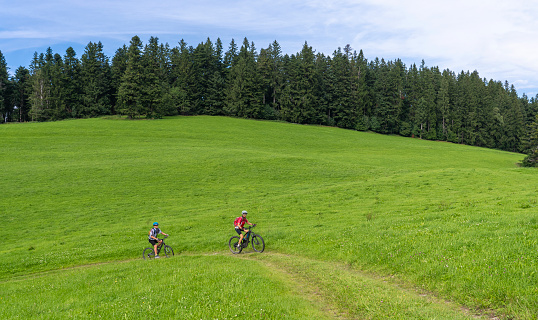 Two people cycling in the Allgaeu Alps near Oberstaufen, Bavaria, Germany