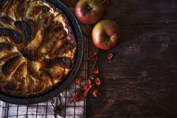 istock Closeup shot of an apple pie and fresh apples on a table 1455451187