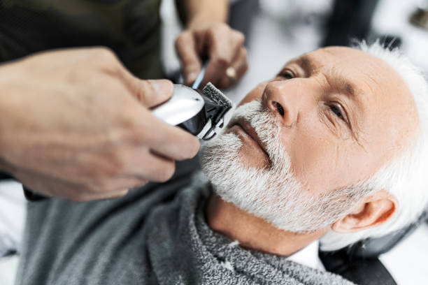 istock Close up of a senior man getting his beard trimmed 1455453142
