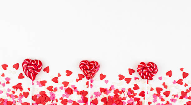 istock Three heart-shaped lollipops for Valentine's day on a white background with small hearts.Flat lay, copy space 1455454168