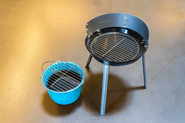 Photo of Camping kettle and barbecue. Goods in the supermarket. Hiking set with grill grate