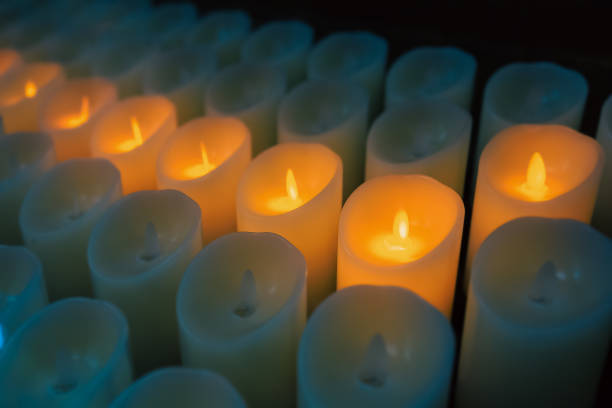 istock Modern electronic candles imitating classic wax candles in a dark temple. Blurred background with selective focus 1455454906