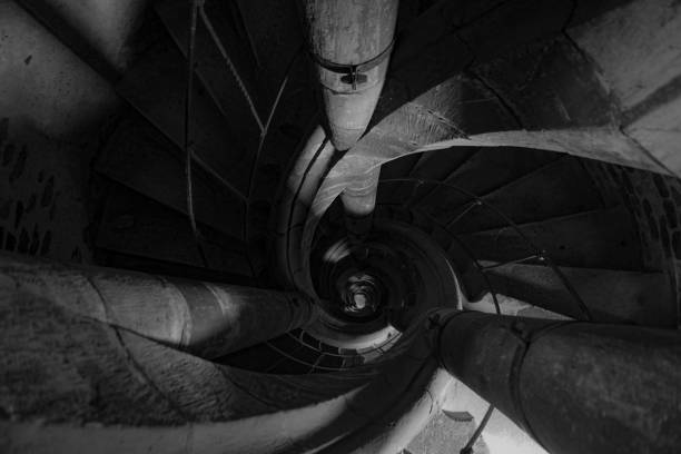 Top view of a spiral stone staircase inside a lighthouse shot in grayscale