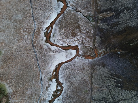 The aerial view of a river in the snowy valley. Reykjadalur, Iceland.