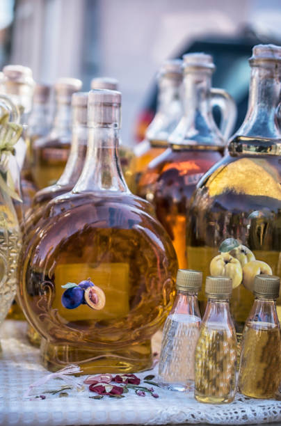 Traditional Balkan plum brandy Traditional Balkan brandies in the bottles on the market stall serbian raki stock pictures, royalty-free photos & images