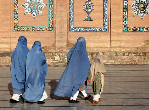 People walk in front of the Great Mosque of Herat in Herat, Afghanistan stock photo