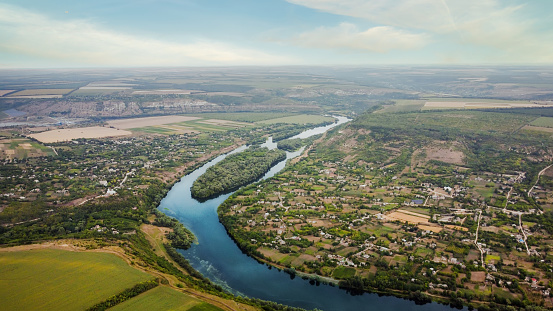 Aerial drone view of nature in Moldova. Dniester river with an island, villages and a lot of greenery around