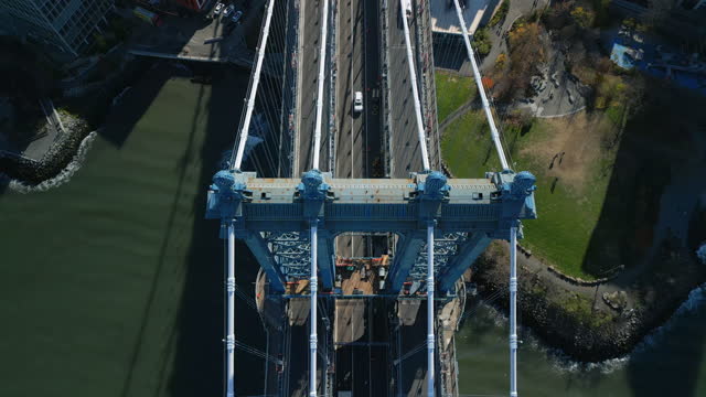 High angle view of big suspension bridge over river. Focused on supporting pillar and ropes. New York City, USA