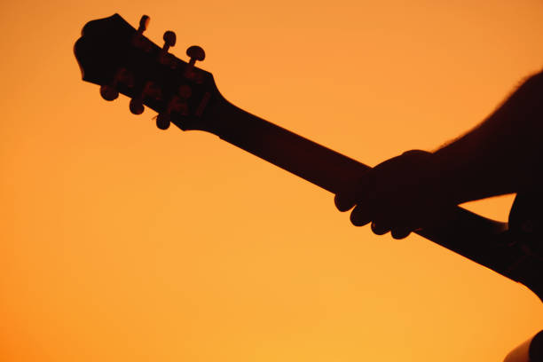 istock Silhouette of an acoustic guitar on sunset. 1455462941