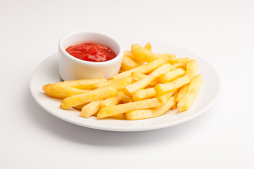 A beautiful photo of a closeup menu of fresh delicious french fries sauce on a plate on a white background