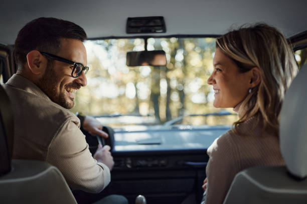 Happy couple talking while traveling by van.