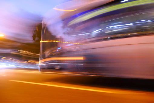 Blurred image of a moving passenger bus on Bondi Road, Bondi. 
 The yellow stripe is the blurred bus number and destination.  This image was achieved with an exposure of 1/2 second shortly after sunset in summer.