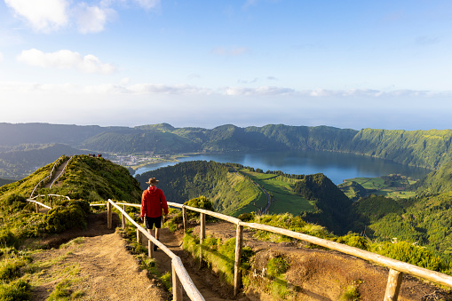 Excursionista con una chaqueta roja en la caldera de la isla de São Miguel en las Azores photo