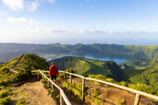 hiker in a red jacket at the caldera on são miguel island in the azores - san miguel imagens e fotografias de stock