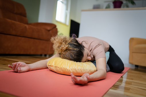 one adult woman caucasian female practice restorative yoga at home