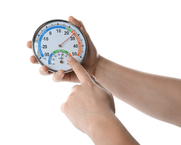 istock Woman holding dial hygrometer on white background, closeup 1455470024