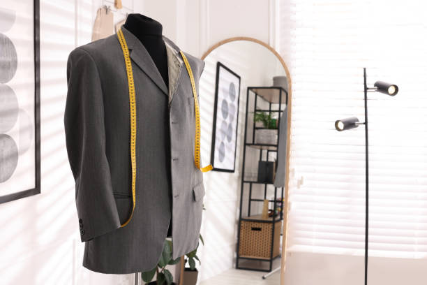 istock Mannequin with unfinished jacket and measuring tape in tailor shop, space for text 1455470144
