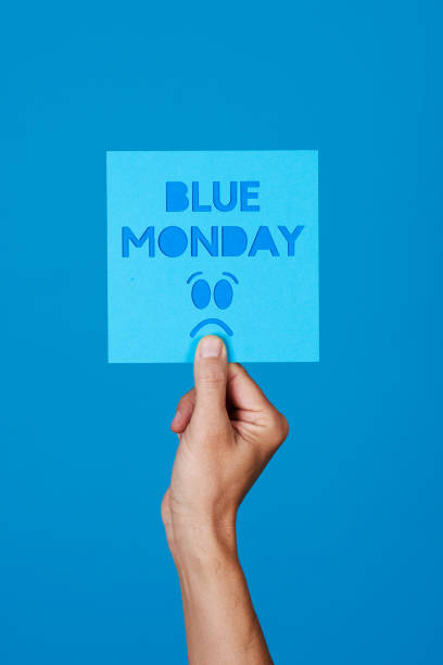 holds a sign with the text blue monday stock photo