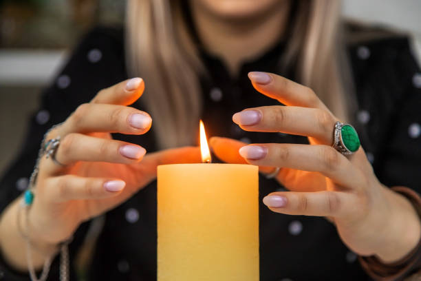 istock Woman fortune teller fortune telling on a candle. Selective focus. 1455473241