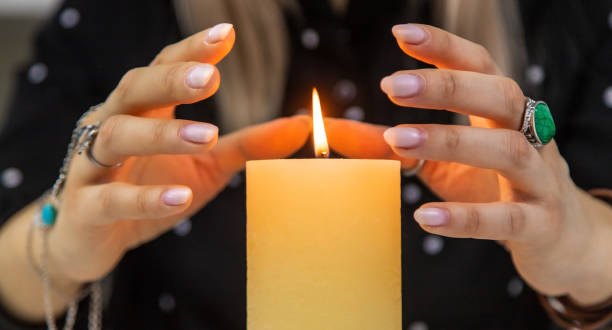 istock Woman fortune teller fortune telling on a candle. Selective focus. 1455473261