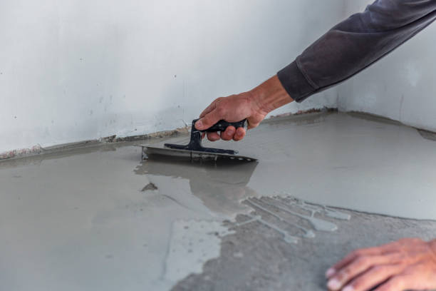 istock Grey self-leveling screed, new floor layer, man hand. 1455477087