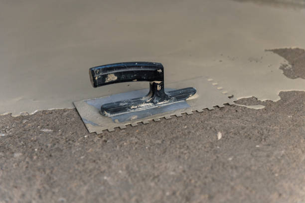 istock Grey self-leveling screed, new floor layer, man hand. 1455477439