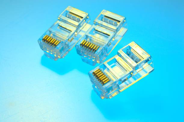 istock Connector rg 45 for internet cable. Several connectors lie on a multi-colored background. Close-up. 1455478185