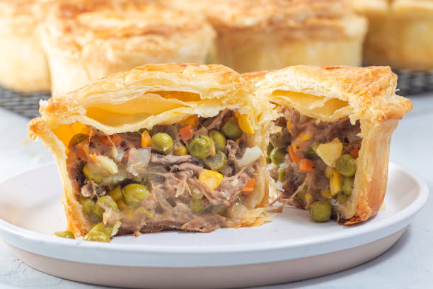 istock Sliced beef pot pie on plate, pies on cooling rack, horizontal 1455478772