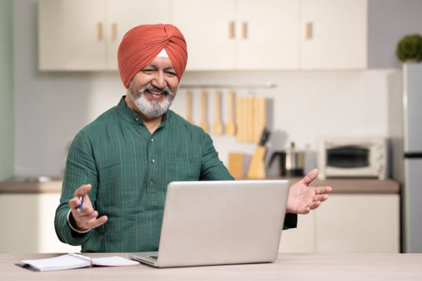 istock Indian sikh man using laptop at home, stock photo 1455479150
