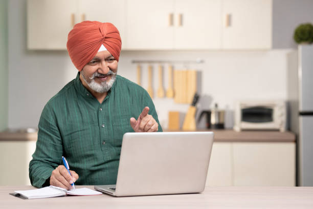 istock Indian sikh man using laptop at home, stock photo 1455479356